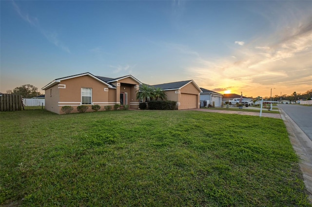 ranch-style house with a front lawn, fence, and stucco siding