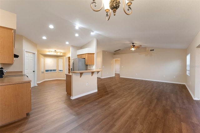 kitchen with a breakfast bar, open floor plan, freestanding refrigerator, light countertops, and ceiling fan with notable chandelier