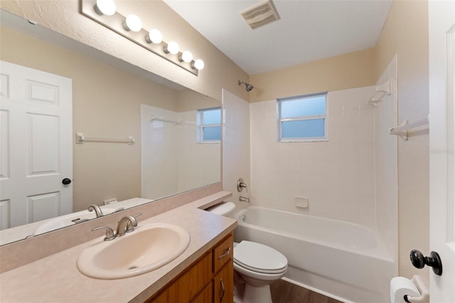 bathroom with visible vents, shower / bathing tub combination, vanity, and toilet