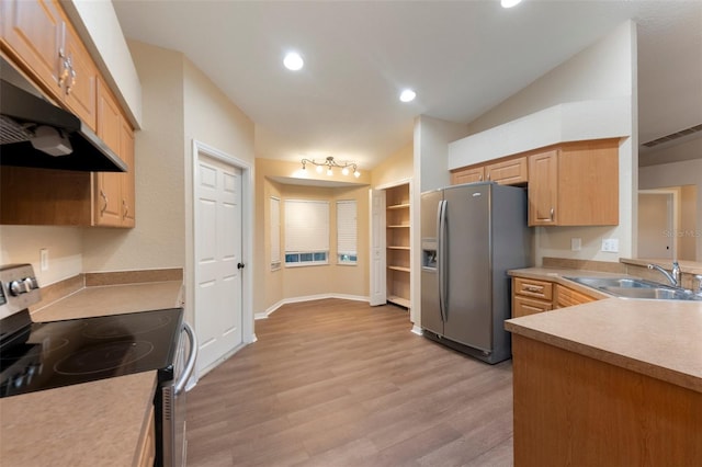 kitchen with light countertops, appliances with stainless steel finishes, vaulted ceiling, a sink, and under cabinet range hood