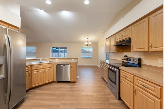 kitchen featuring pendant lighting, light countertops, appliances with stainless steel finishes, a sink, and under cabinet range hood