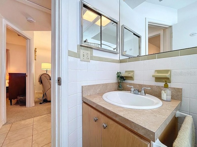 bathroom featuring tile patterned flooring, vanity, and tile walls