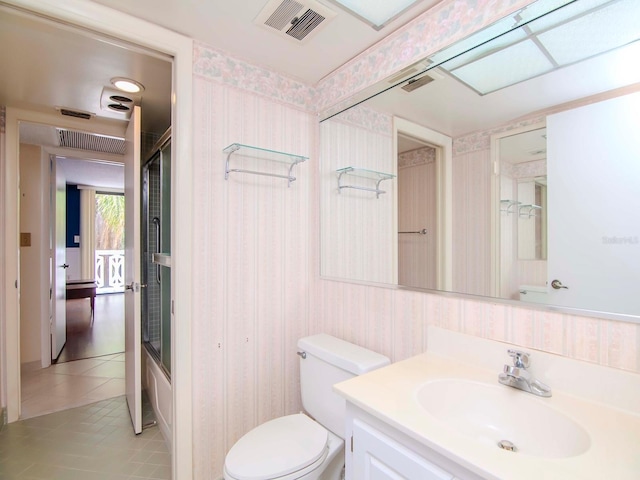 full bathroom featuring tile patterned floors, vanity, toilet, and enclosed tub / shower combo