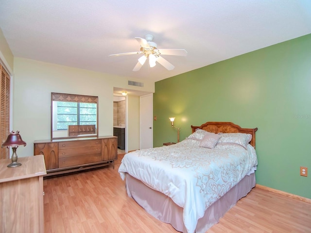 bedroom featuring ceiling fan, light wood-type flooring, ensuite bathroom, and a closet