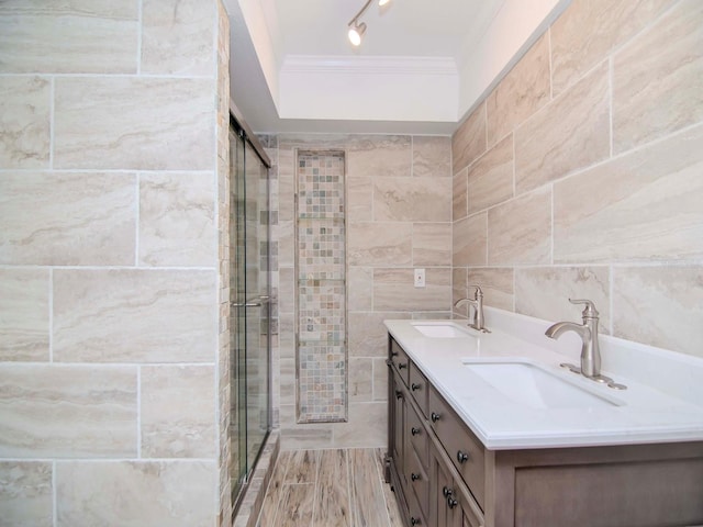 bathroom with tile walls, vanity, an enclosed shower, and ornamental molding