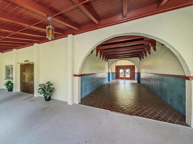 interior space featuring carpet floors, beamed ceiling, and wood ceiling