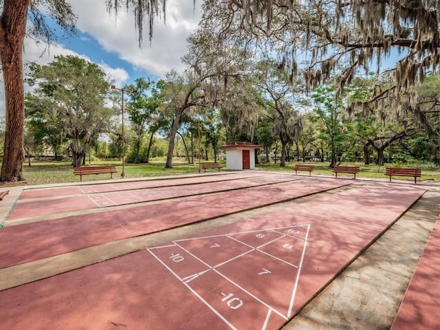 view of property's community with an outdoor structure and shuffleboard