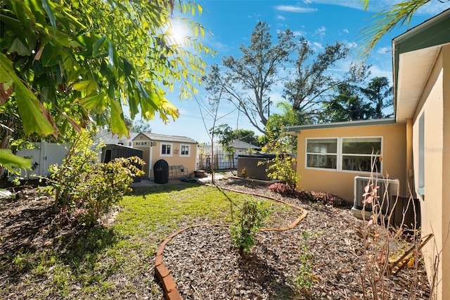 view of yard featuring central AC, a jacuzzi, and a shed