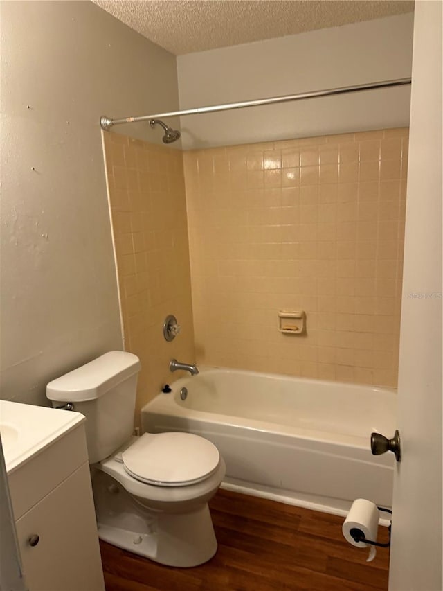 full bathroom with vanity, a textured ceiling, wood-type flooring, shower / bathing tub combination, and toilet