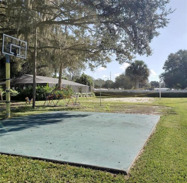 view of property's community featuring a lawn, basketball hoop, and volleyball court