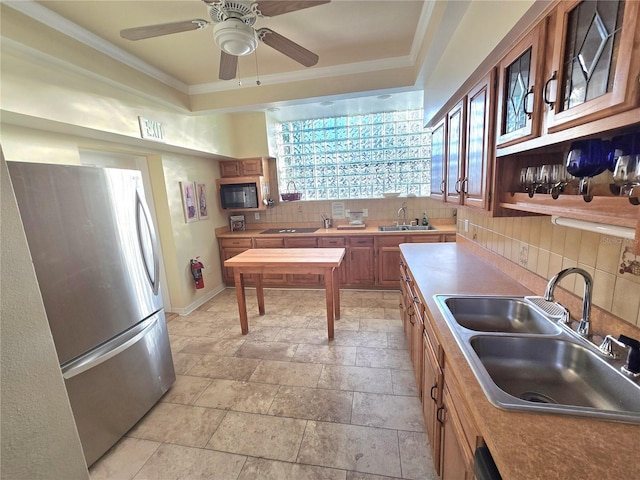 kitchen featuring decorative backsplash, stainless steel refrigerator, ceiling fan, and sink