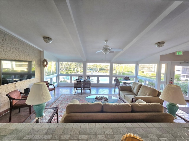 sunroom featuring vaulted ceiling with beams, ceiling fan, and a healthy amount of sunlight