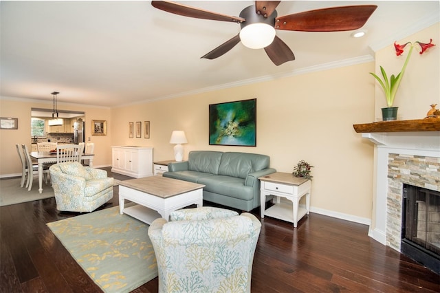 living room with ornamental molding, a fireplace, and dark wood-type flooring