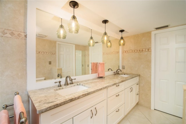 bathroom featuring vanity, tile patterned floors, and tile walls