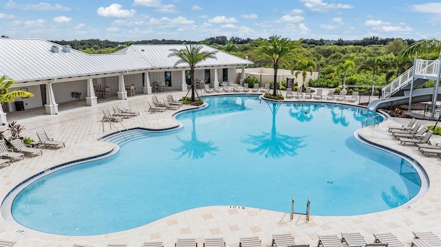 view of swimming pool with a patio and a water slide