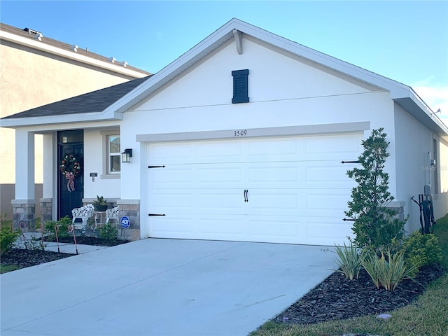 view of front of house featuring stone siding, concrete driveway, an attached garage, and stucco siding