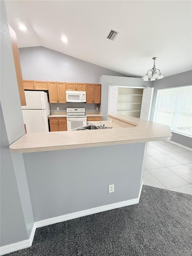 kitchen featuring lofted ceiling, white appliances, an inviting chandelier, light colored carpet, and kitchen peninsula