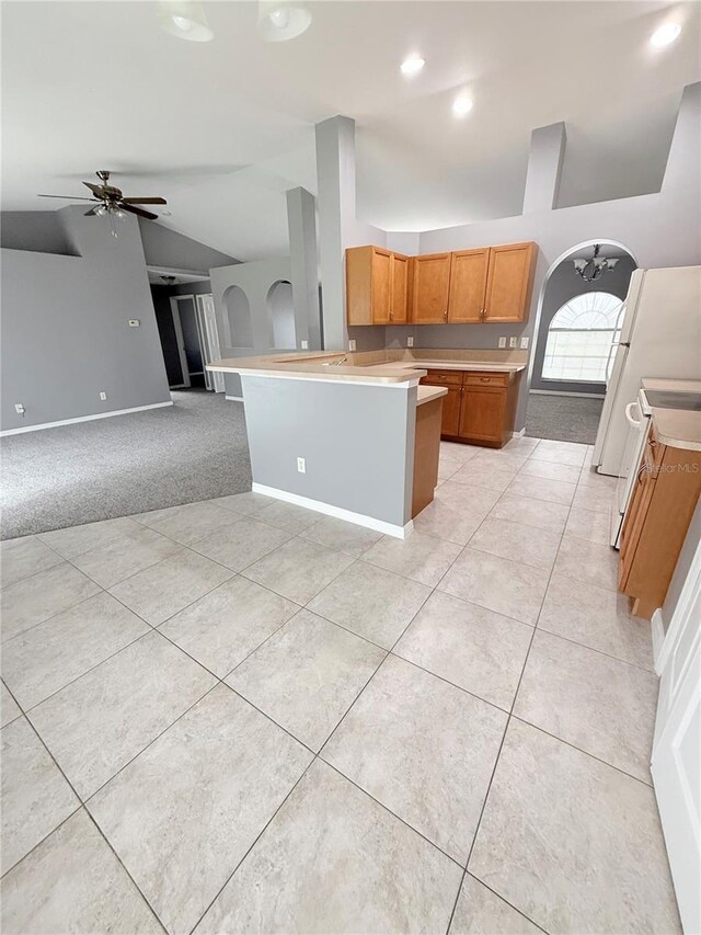 kitchen featuring ceiling fan, white range oven, kitchen peninsula, lofted ceiling, and light carpet