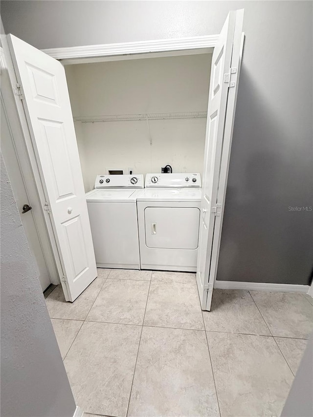 clothes washing area featuring independent washer and dryer and light tile patterned floors