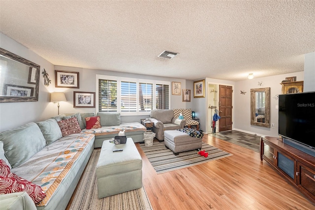 living room featuring a textured ceiling and light wood-type flooring