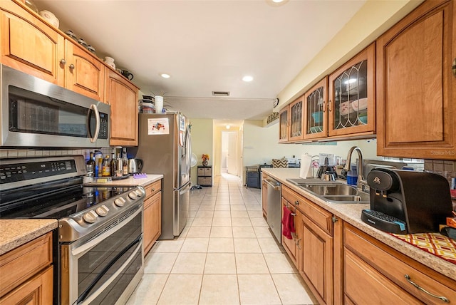 kitchen with sink, light tile patterned flooring, and appliances with stainless steel finishes