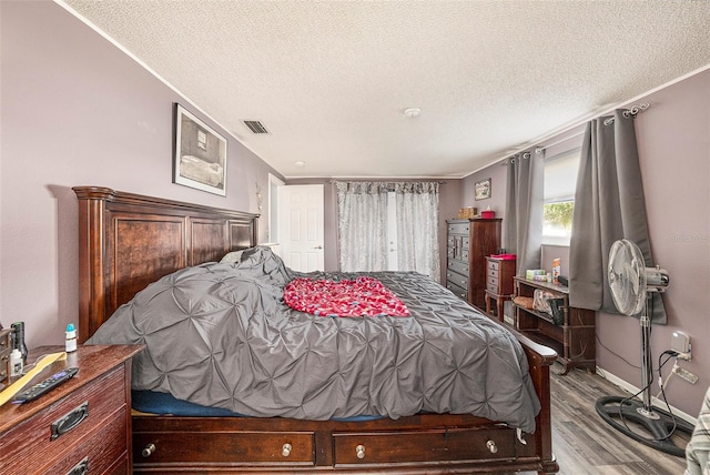 bedroom featuring light wood-type flooring and a textured ceiling