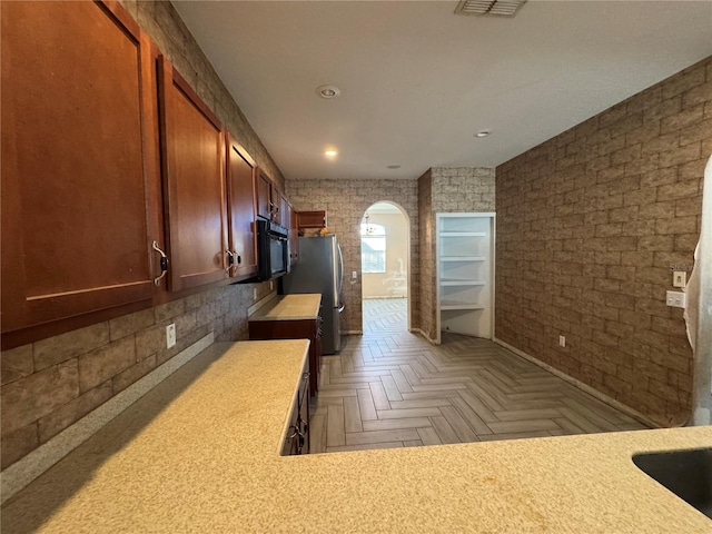 kitchen featuring stainless steel fridge and parquet flooring