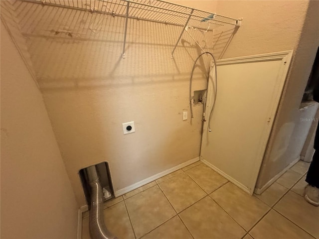 clothes washing area with hookup for an electric dryer, hookup for a washing machine, and tile patterned floors