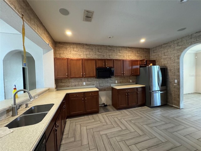 kitchen with stainless steel fridge, sink, and light parquet flooring