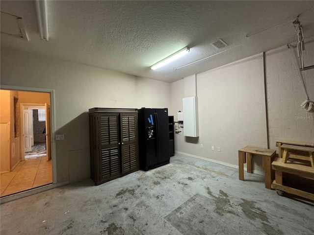 basement with a textured ceiling and electric panel