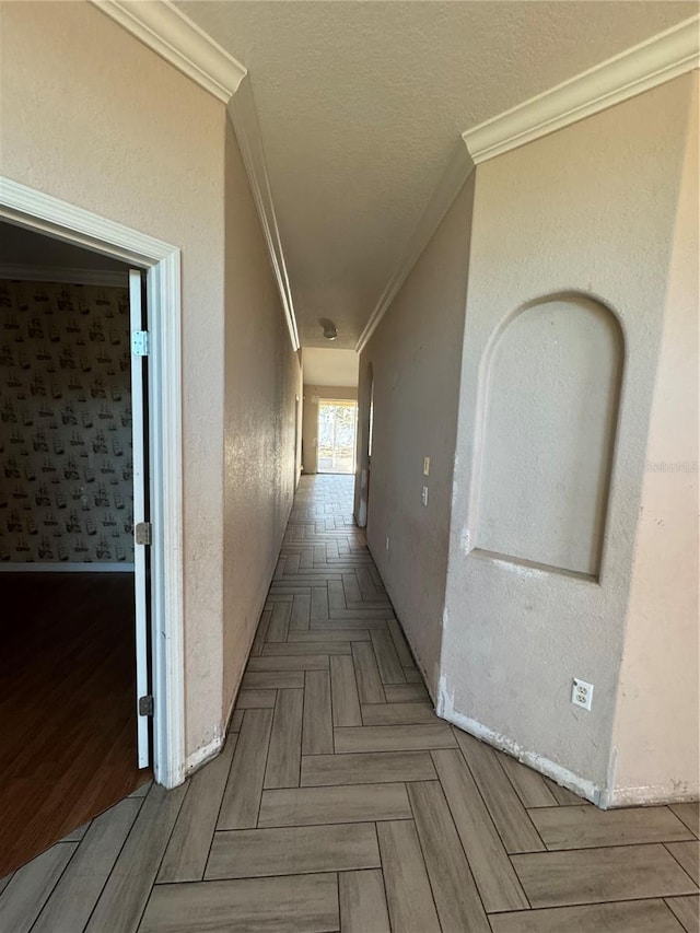 hall with a textured ceiling, parquet floors, and crown molding