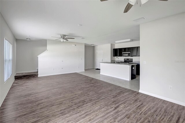 unfurnished living room with ceiling fan, light hardwood / wood-style flooring, and sink