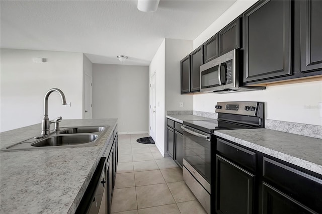 kitchen featuring light tile patterned floors, a textured ceiling, stainless steel appliances, and sink