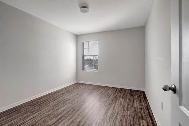 empty room with dark hardwood / wood-style flooring