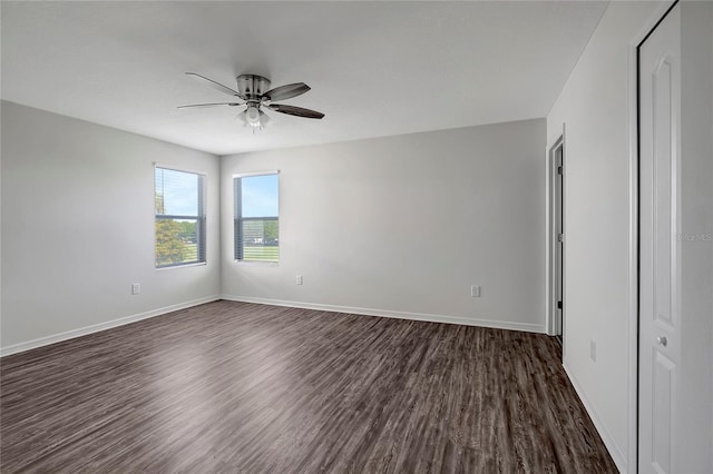 unfurnished room with ceiling fan and dark wood-type flooring