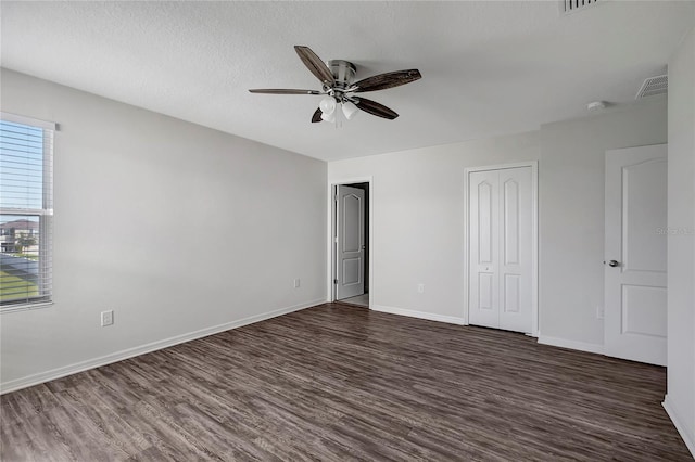 unfurnished bedroom with ceiling fan, dark hardwood / wood-style flooring, and a textured ceiling