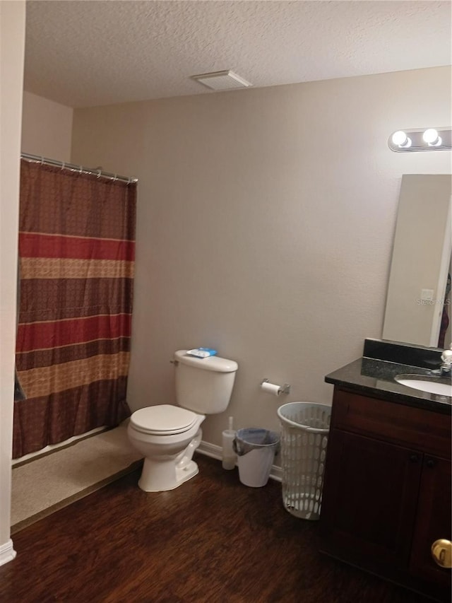 bathroom featuring toilet, vanity, wood-type flooring, a textured ceiling, and a shower with shower curtain