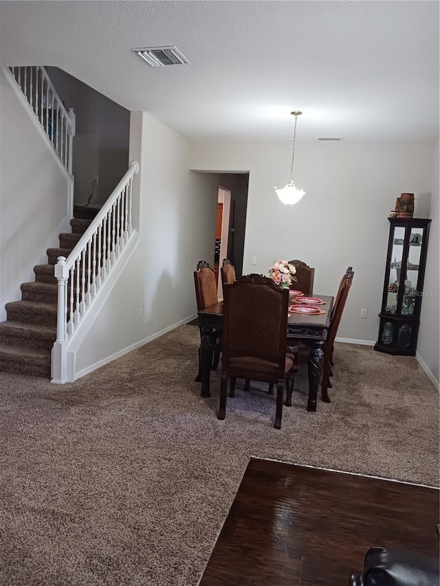 carpeted dining space featuring an inviting chandelier