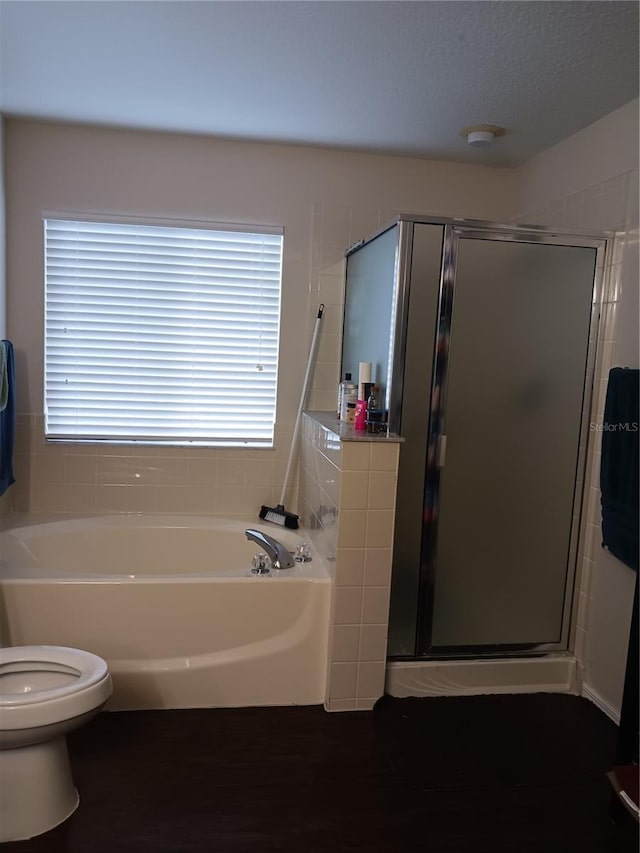 bathroom featuring toilet, a healthy amount of sunlight, and shower with separate bathtub