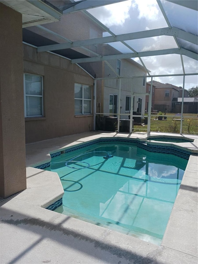 view of swimming pool featuring an in ground hot tub, a lanai, and a patio