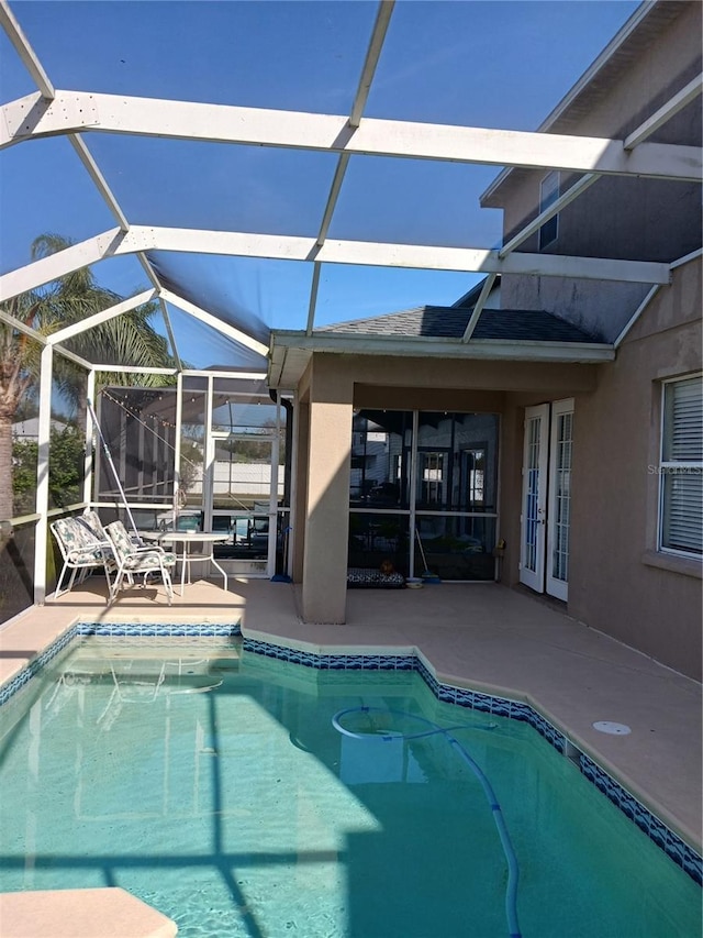 view of swimming pool with glass enclosure and a patio area