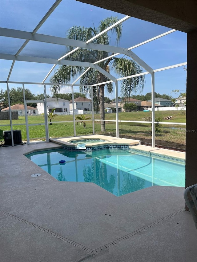 view of pool with a yard, glass enclosure, a patio, central AC, and a pool with connected hot tub