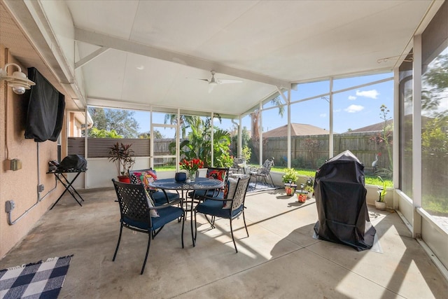 sunroom featuring ceiling fan and vaulted ceiling with beams