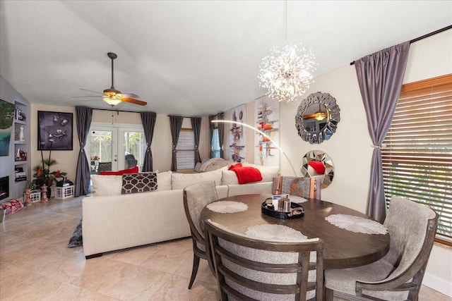 dining area with lofted ceiling, ceiling fan with notable chandelier, and french doors