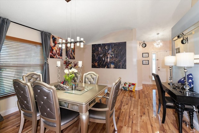 dining area featuring a notable chandelier, wood-type flooring, and a healthy amount of sunlight