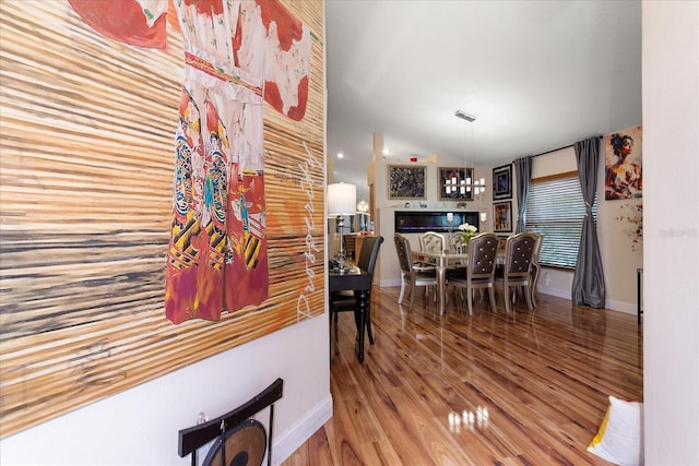 dining area with hardwood / wood-style flooring, vaulted ceiling, and a fireplace