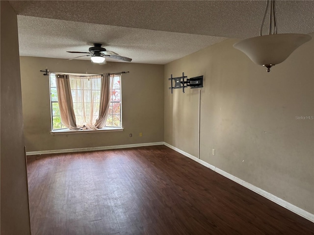 unfurnished room featuring ceiling fan, dark wood-type flooring, and a textured ceiling