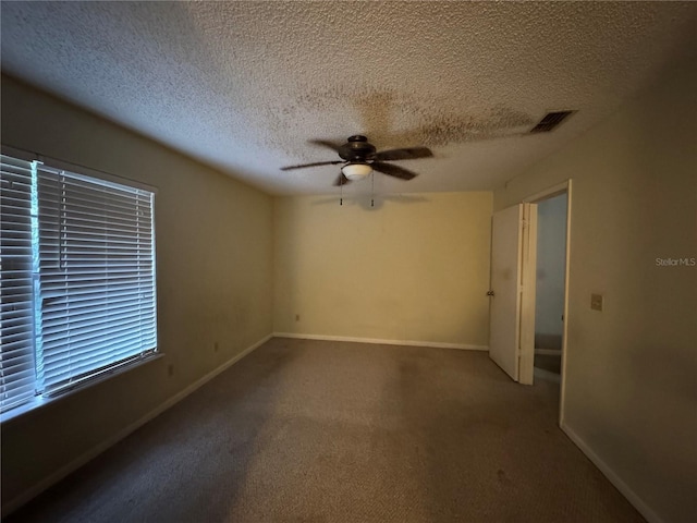 empty room featuring ceiling fan, carpet floors, and a textured ceiling