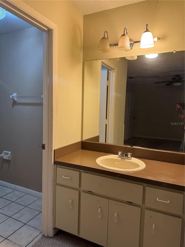 bathroom featuring tile patterned flooring, vanity, and a textured ceiling