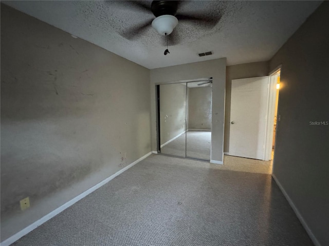 unfurnished bedroom with ceiling fan, a closet, and a textured ceiling